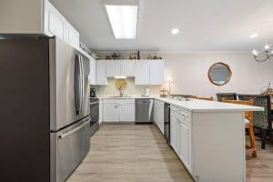a kitchen with white cabinets and a black refrigerator at Marlin Key 1B in Orange Beach