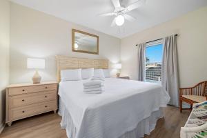 a white bedroom with a bed and a window at Marlin Key 1B in Orange Beach