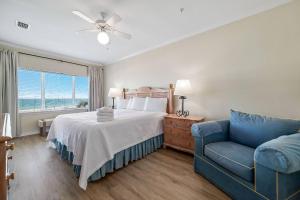 a bedroom with a bed and a blue couch at Marlin Key 1B in Orange Beach