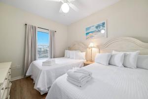 a bedroom with two beds with white sheets and a window at Marlin Key 1B in Orange Beach +42 photos