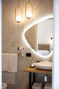ein Badezimmer mit Waschbecken und Spiegel in der Unterkunft Sky Touch Suites Napoli in Neapel