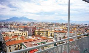 Blick auf eine Stadt mit Gebäuden und Bergen in der Unterkunft Sky Touch Suites Napoli in Neapel