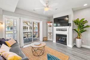 a living room with a couch and a fireplace at Just Peachy VillageOBX in Kill Devil Hills