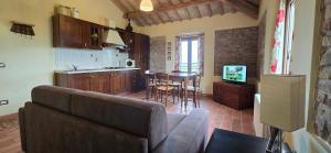 a living room with a couch and a kitchen at Agriturismo Papaveri e Papere in Saludecio