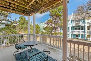 a patio with a table and chairs on a porch at Just Peachy VillageOBX in Kill Devil Hills