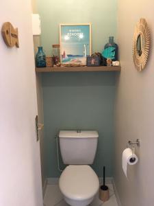 a bathroom with a toilet with a shelf above it at Studio Bénodet vue mer in Bénodet +15 photos