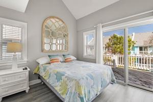 a bedroom with a bed and a large window at Just Peachy VillageOBX in Kill Devil Hills +23 photos