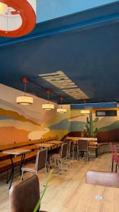 a restaurant with tables and chairs and a painting on the wall at Zamia Hostel in Bucaramanga +34 photos