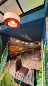 a dining room with tables and chairs and plants at Zamia Hostel in Bucaramanga