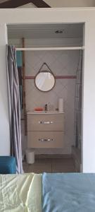 a bedroom with a sink and a mirror on the wall at Kaz l'Oranger in Saint Esprit