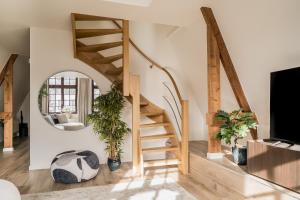 a spiral staircase in a living room with a mirror at Heritage Suites Antwerp in Antwerp