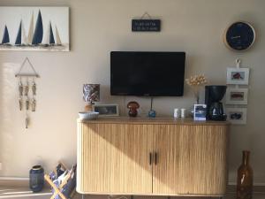 a tv on top of a wooden cabinet in a room at Studio Bénodet vue mer in Bénodet