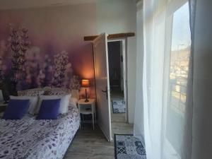 a bedroom with a bed with blue pillows at La Tulipe Périgourdine in Le Buisson de Cadouin