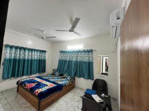 a bedroom with a bed and a ceiling fan at Ranchhod Villa in Marwad