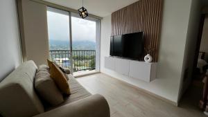 a living room with a couch and a flat screen tv at Posada del Quindío 0812 in Armenia