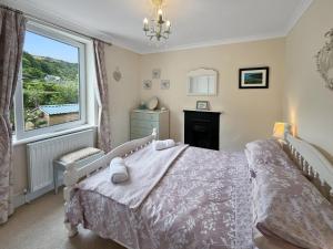 a bedroom with a bed and a large window at Pips Corner Lynton in Lynton