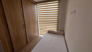 a room with a bed and a window with blinds at Posada del Quindío 0812 in Armenia