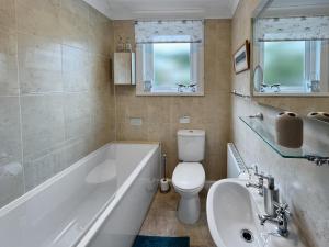a bathroom with a tub and a toilet and a sink at Pips Corner Lynton in Lynton +36 photos