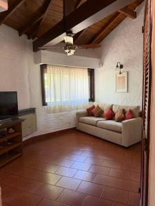 a living room with a couch and a television at LPR EZE Airport in La Unión