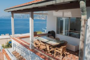 a patio with a table and chairs on a balcony at Casacasa Praiano in Praiano