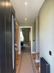 a hallway with a door leading to a living room at Cadderlie Cabin - Luxury Woodland Escape with Hot Tub Near Oban in Oban