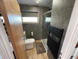 a small bathroom with a toilet and a window at Cadderlie Cabin - Luxury Woodland Escape with Hot Tub Near Oban in Oban +12 photos