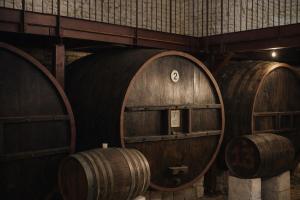 three wooden wine barrels in a room with a wall at Tenuta Colavecchio Wine Relais in Putignano +30 photos