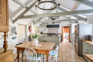 a kitchen with a wooden table and chairs at Berehayes Farmhouse in Bridport