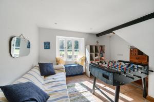 a living room with a foos ball on a table at Berehayes Farmhouse in Bridport