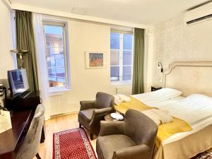 a bedroom with a bed and a chair and a television at Hotel Concordia in Lund