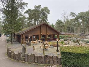 a wooden cabin with a table and chairs in front of it at Private Chalet Heppie People in Doornspijk