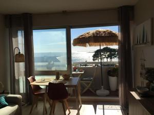 a living room with a table and an umbrella at Studio Bénodet vue mer in Bénodet