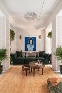 a living room with a green couch and a coffee table at Riad Dar des Arts in Marrakesh