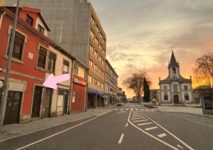 an empty city street with a pink arrow pointing to a building at Casa Quixote Matosinhos in São Mamede de Infesta