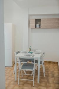a white dining table and chairs in a kitchen at Casacasa Praiano in Praiano