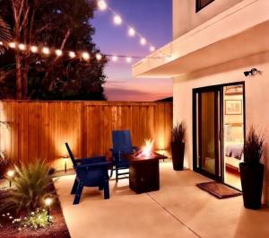 a patio with a table and chairs and lights at 2026 Award Winner, Luxe 2BR, steps to sand & pier, with fire pit, AC and parking in Newport Beach