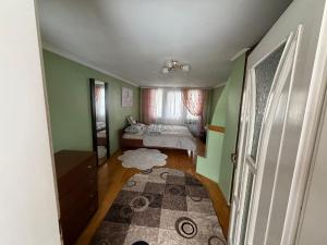 a bedroom with green walls and a bed and a rug at Власний будинок in Rakhiv