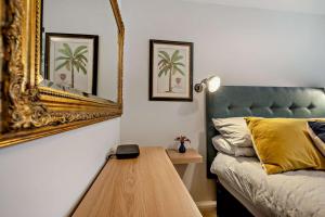 a bedroom with a bed with a mirror and a table at 1 Bed in Putsborough oc-b28792 in Croyde +7 photos