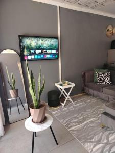 a living room with a couch and a tv on the wall at SinoVilla397 in Pretoria