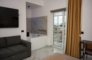 ein Wohnzimmer mit Sofa und großem Fenster in der Unterkunft Sky Touch Suites Napoli in Neapel + 70 Fotos