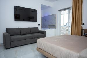 ein Schlafzimmer mit einem Bett und einer Couch in der Unterkunft Sky Touch Suites Napoli in Neapel