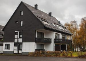 ein schwarzes und weißes Haus mit einem Gameradach in der Unterkunft Welcome in - Appartement met parking & skiberging, terras, centraal gelegen in Winterberg