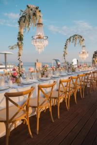 a long table with chairs and flowers on a deck at La Brisa Boutique Hotel in Dhërmi +61 photos