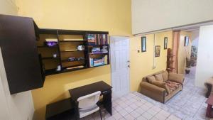 a living room with a desk and a couch at Elaine's Hideaway in Point Fortin