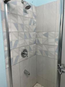 a shower with blue and white tiles in a bathroom at Elaine's Hideaway in Point Fortin