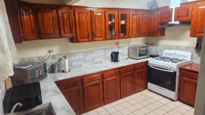 a kitchen with wooden cabinets and a stove top oven at Elaine's Hideaway in Point Fortin