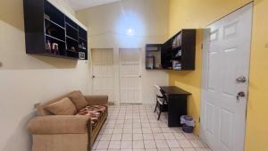 a small living room with a couch and a desk at Elaine's Hideaway in Point Fortin +3 photos