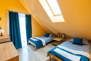 two beds in a room with a window at Apartamenty Sawino 4 in Tykocin