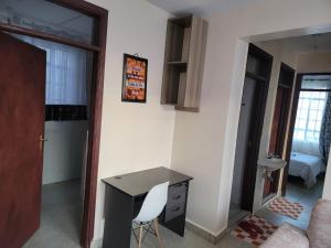 a desk and chair in a room with a bedroom at Serenity Homes in Gatunga