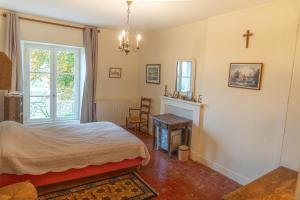 a bedroom with a bed and a cross on the wall at Manoir de Pincelu in La Courbe